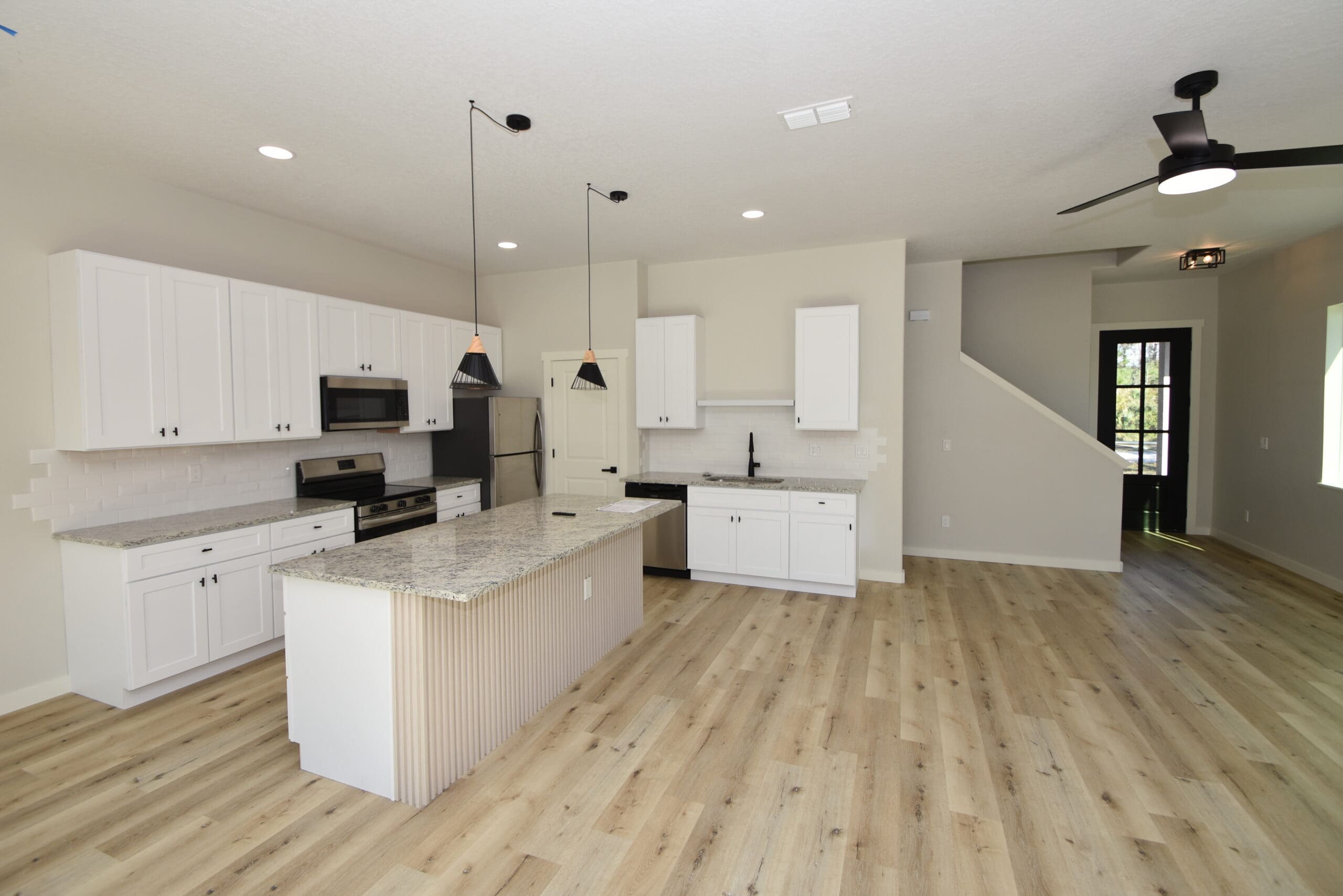 White shaker kitchen cabinets with island and pendant lighting
